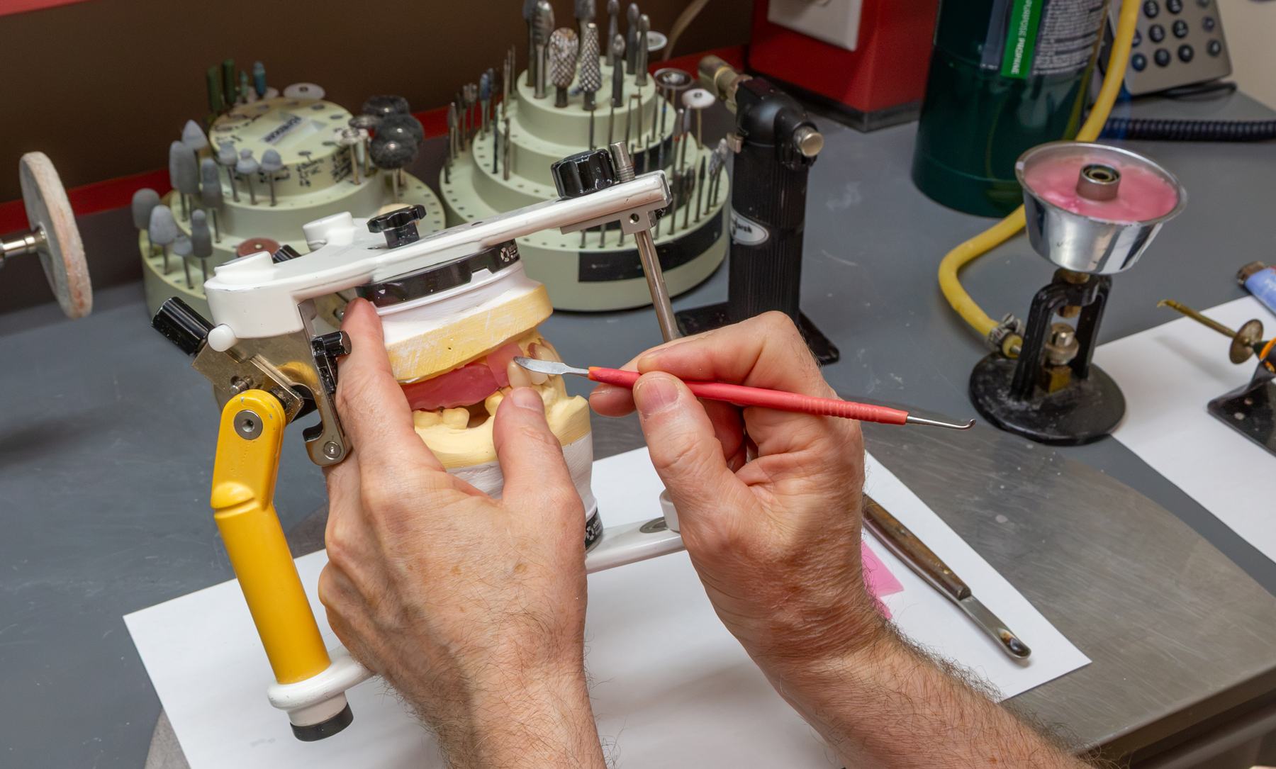 Michael Watson hand-finishing a denture on an articulator