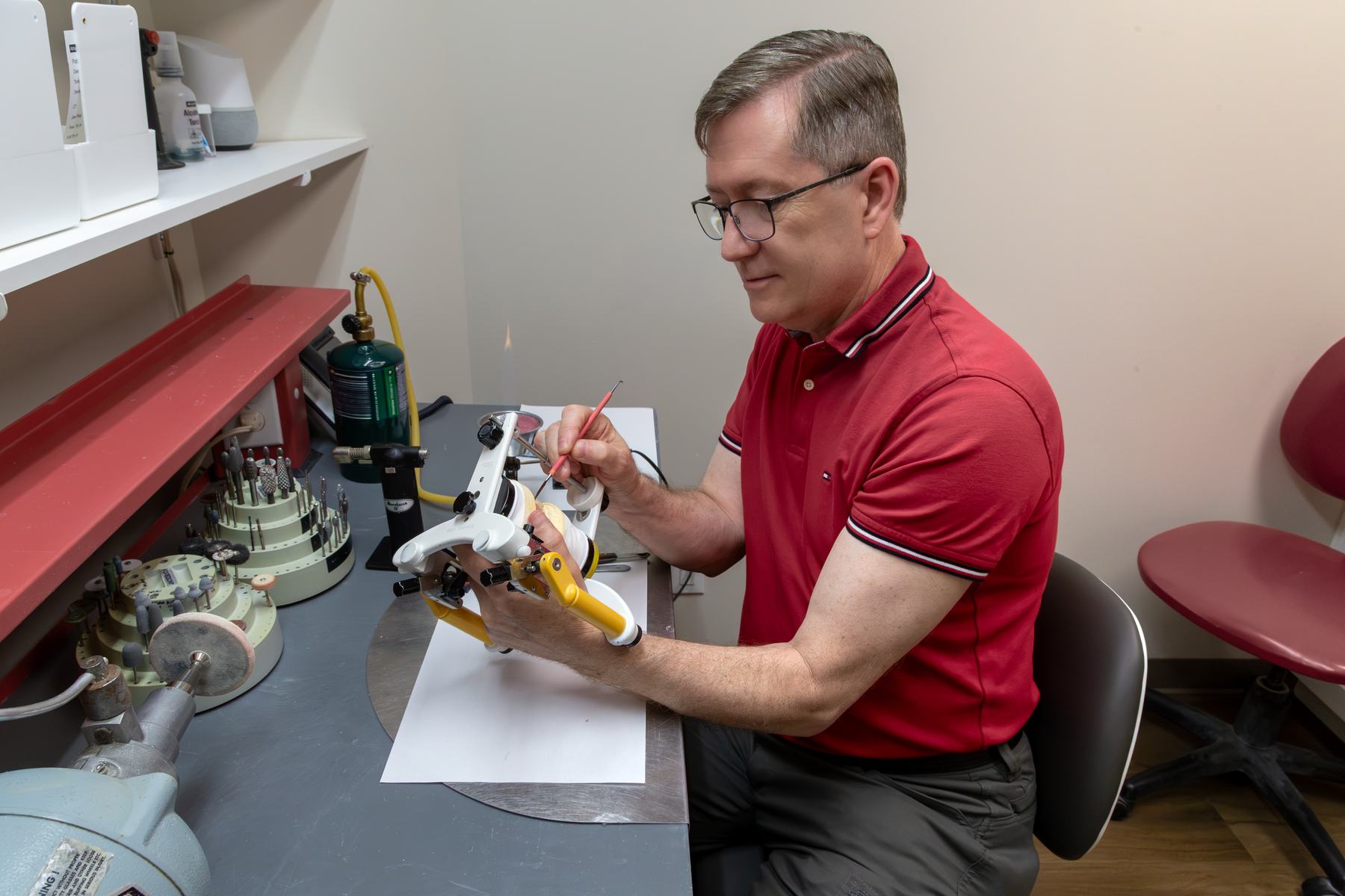 Michael Watson repairing a denture at the lab bench