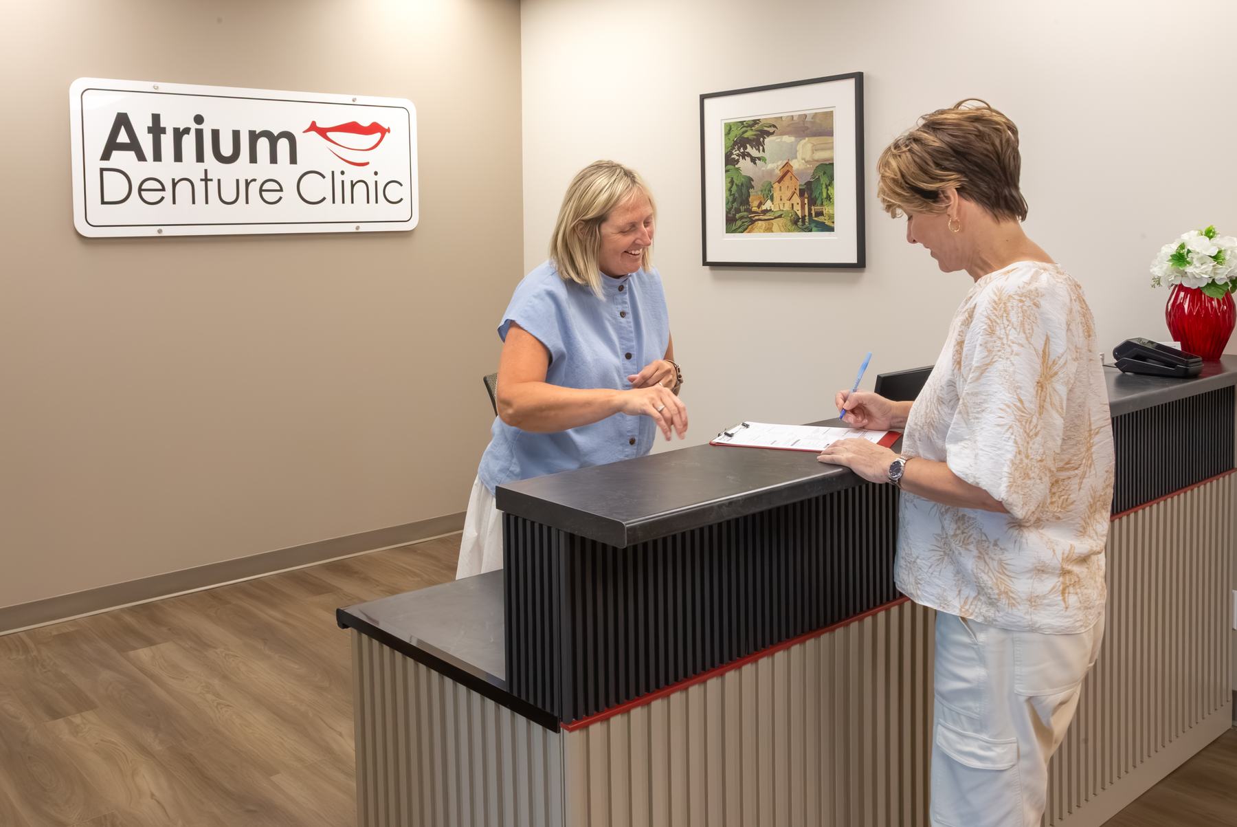 Deb Miller welcoming a patient at the Atrium reception desk